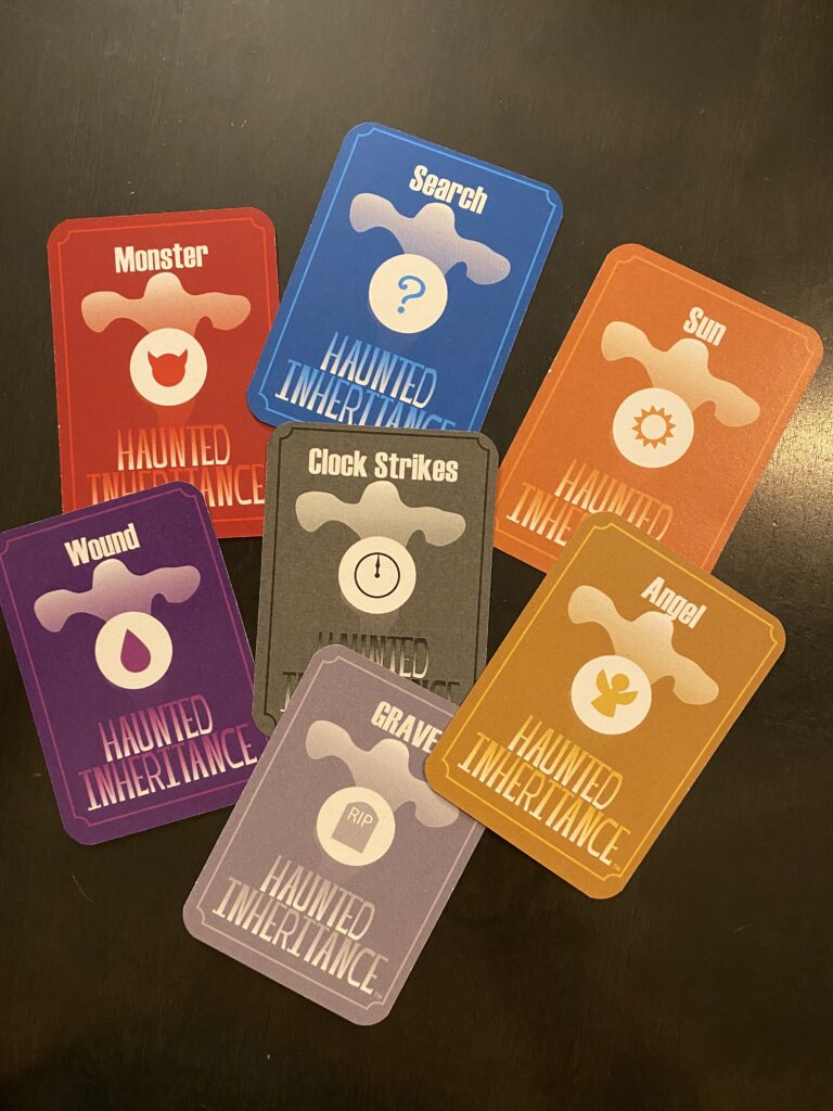 The 7 colored cards for Haunted Inheritance: Red monster, blue search, orange Sunrise, purple wound, black Clock Strike, Gold angel, and grey Zombie cards