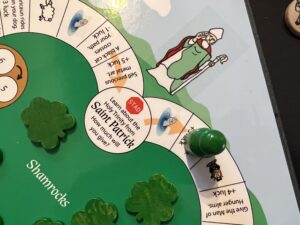 St. Patrick loop of the game board with shamrocks on board and green pawn leaving St. Patrick space.