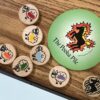 small wooden tokens with sheep with different colored paint on their butts and a large Pooka Pile disc with a magical horse