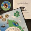 Luck: Legends of Ireland board game corner, large disc labeled 'Pooka Pile' with Luck coins and a booklet displayed of the legends of Ireland explained